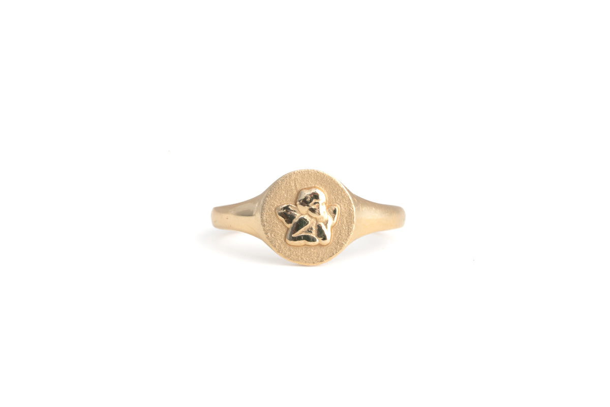 cherub signet ring in gold on a white background