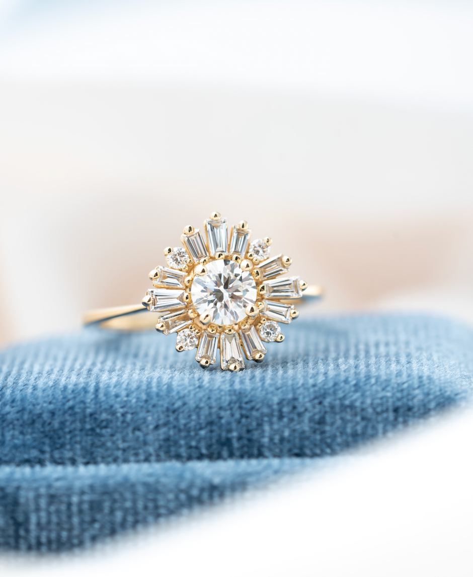 Gold ring with a diamond on a blue textured surface