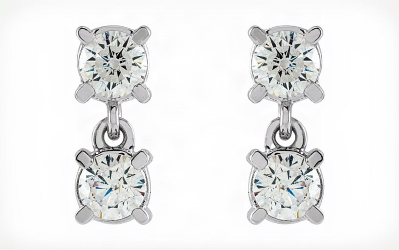 Pair of silver earrings with clear gemstones on a white background