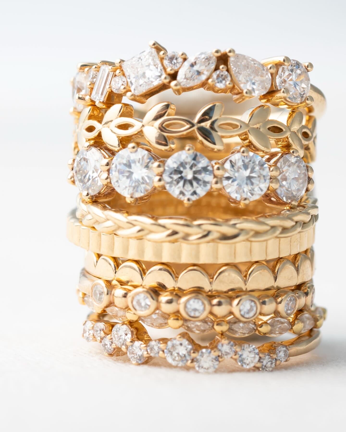 Large stack of solid gold and diamond rings. Women's stacking rings.